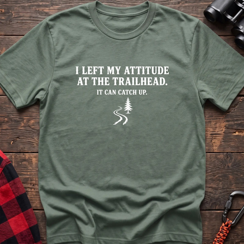 Sage cotton t-shirt with a trail graphic and I Left My Attitude at the Trailhead It Can Catch Up text on rustic wood