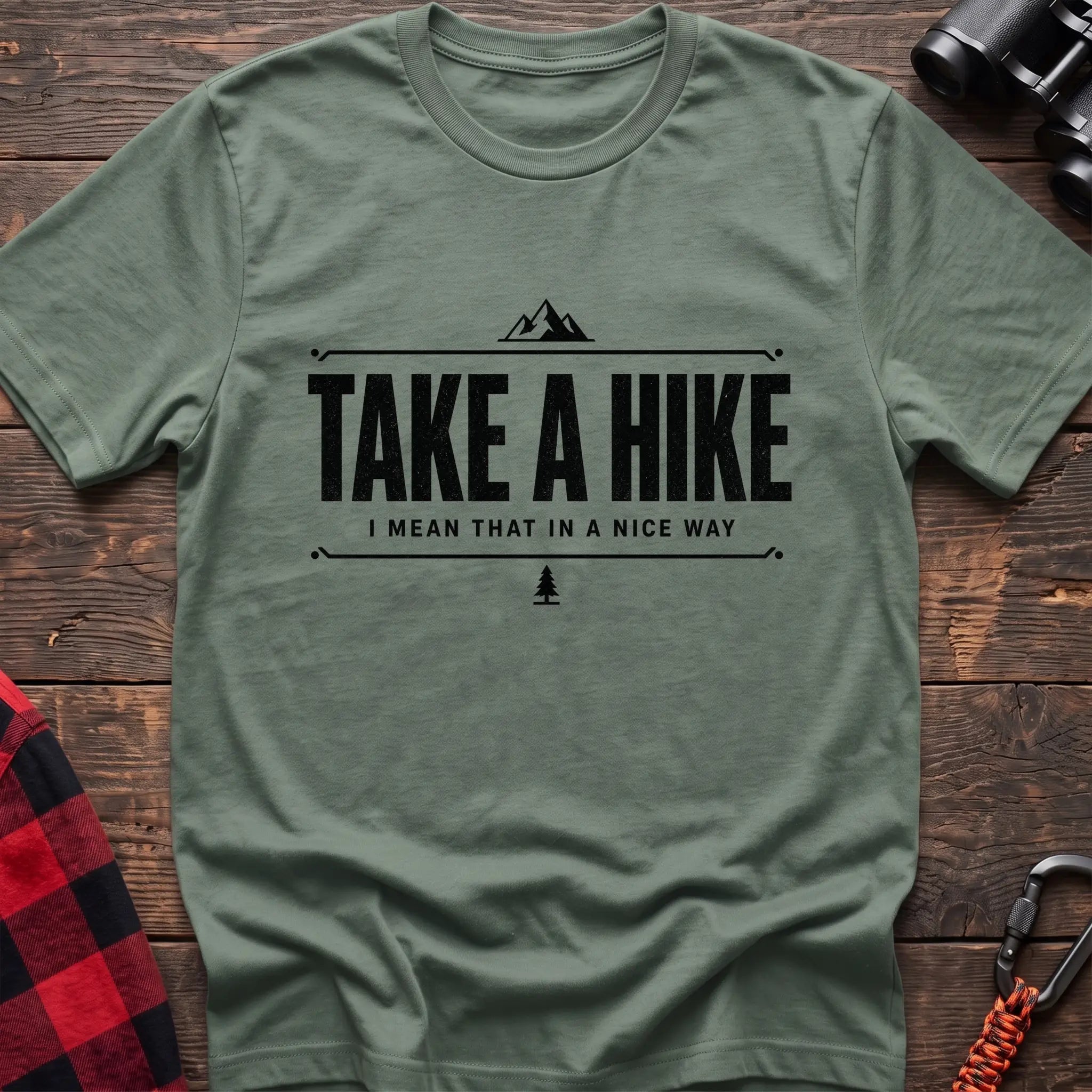 Sage cotton hiking t-shirt with "Take a Hike I Mean That in a Nice Way" quote, mountain icon, and pine tree graphic