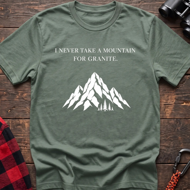 Sage cotton t-shirt with a mountain graphic and I Never Take a Mountain for Granite text on rustic wood