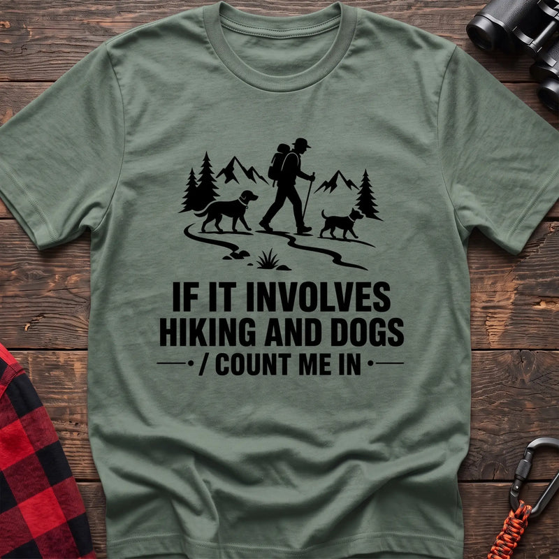 Sage cotton hiking t-shirt with hiker and two dogs silhouette on a mountain trail and "If it involves hiking and dogs count me in" quote