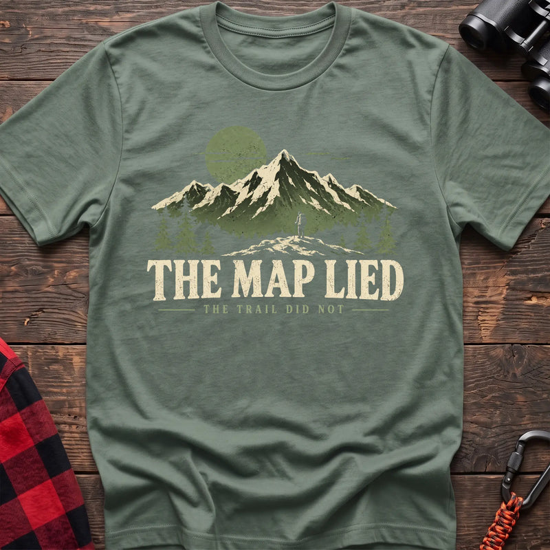 Sage cotton t-shirt with a hiker and mountain graphic and The Map Lied The Trail Did Not text on rustic wood