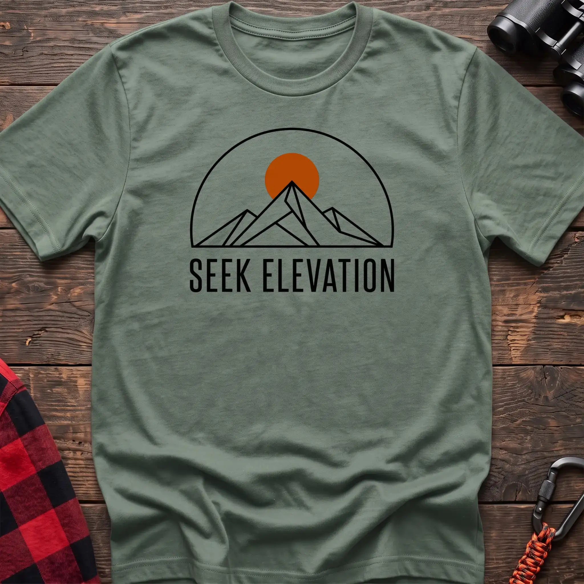 Sage t-shirt with minimalist mountain and sun graphic reading Seek Elevation