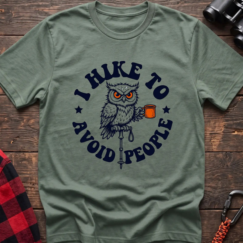 Sage t-shirt with owl holding a camping mug on a hiking pole and the text I Hike to Avoid People