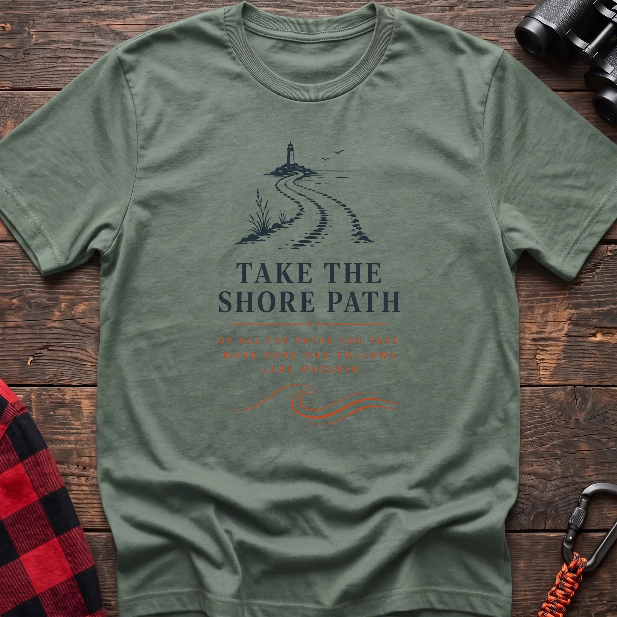 Sage cotton hiking t-shirt with lighthouse and winding shore path graphic and "Take the Shore Path – make sure one follows Lake Ontario" quote