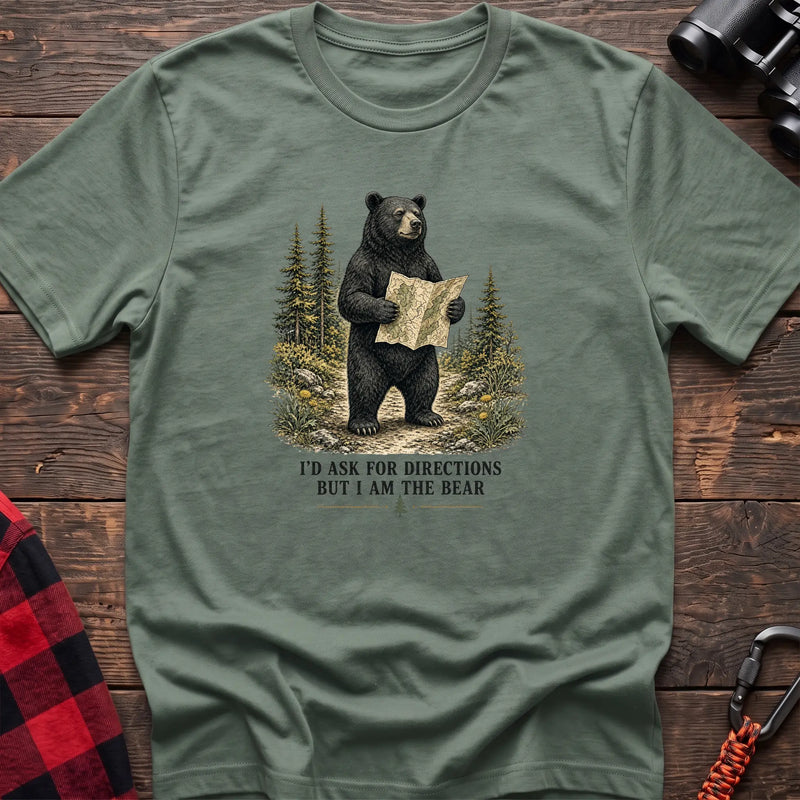 Sage cotton t-shirt with a bear holding a map graphic and I’d Ask for Directions But I Am the Bear text on rustic wood