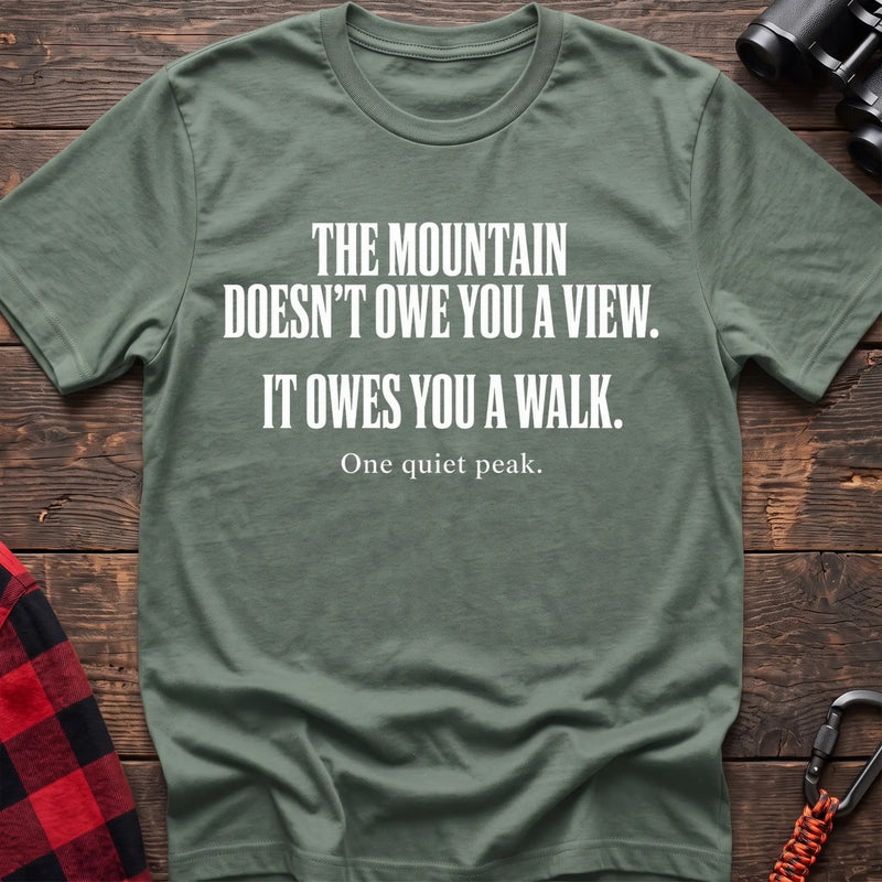 Sage cotton t-shirt with The Mountain Doesn’t Owe You a View It Owes You a Walk text on rustic wood