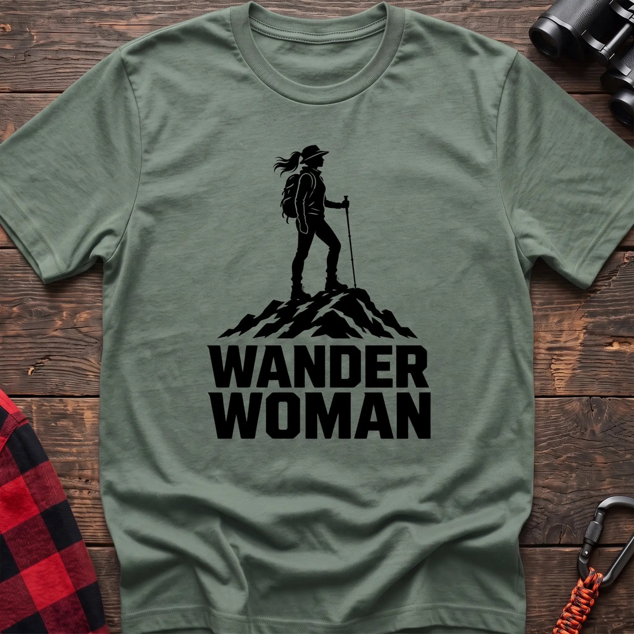 Sage cotton hiking t-shirt with black silhouette of a female hiker on a mountain peak and bold Wander Woman text
