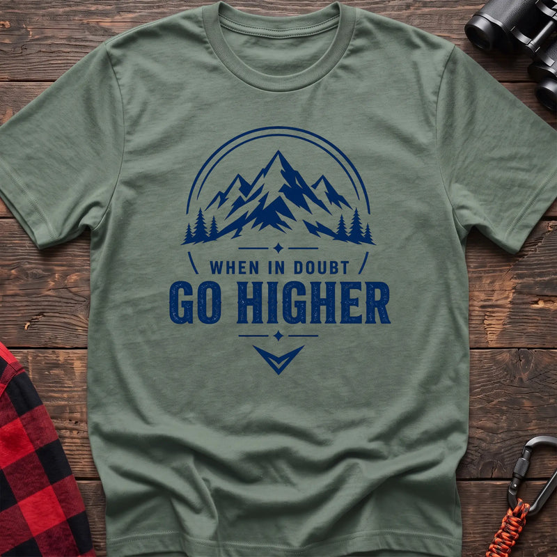 Sage cotton hiking t-shirt with navy mountain and pine tree graphic and "When in doubt go higher" quote