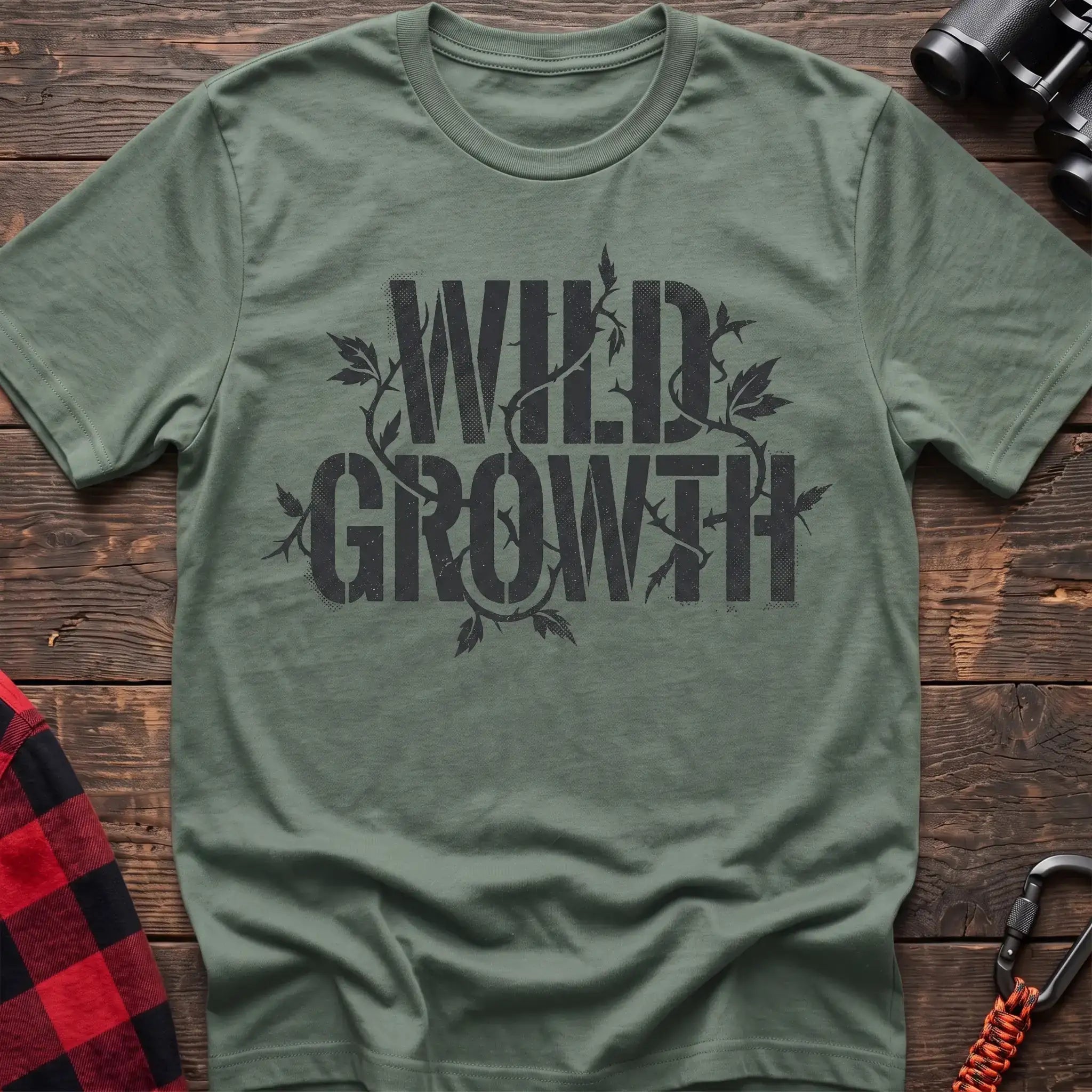Sage t-shirt with dark text reading Wild Growth intertwined with thorny vines and leaves