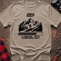 Sand t-shirt with black graphic of a hiker on a mountain trail under pixel-style 1UP text and a progress bar reading Level Up