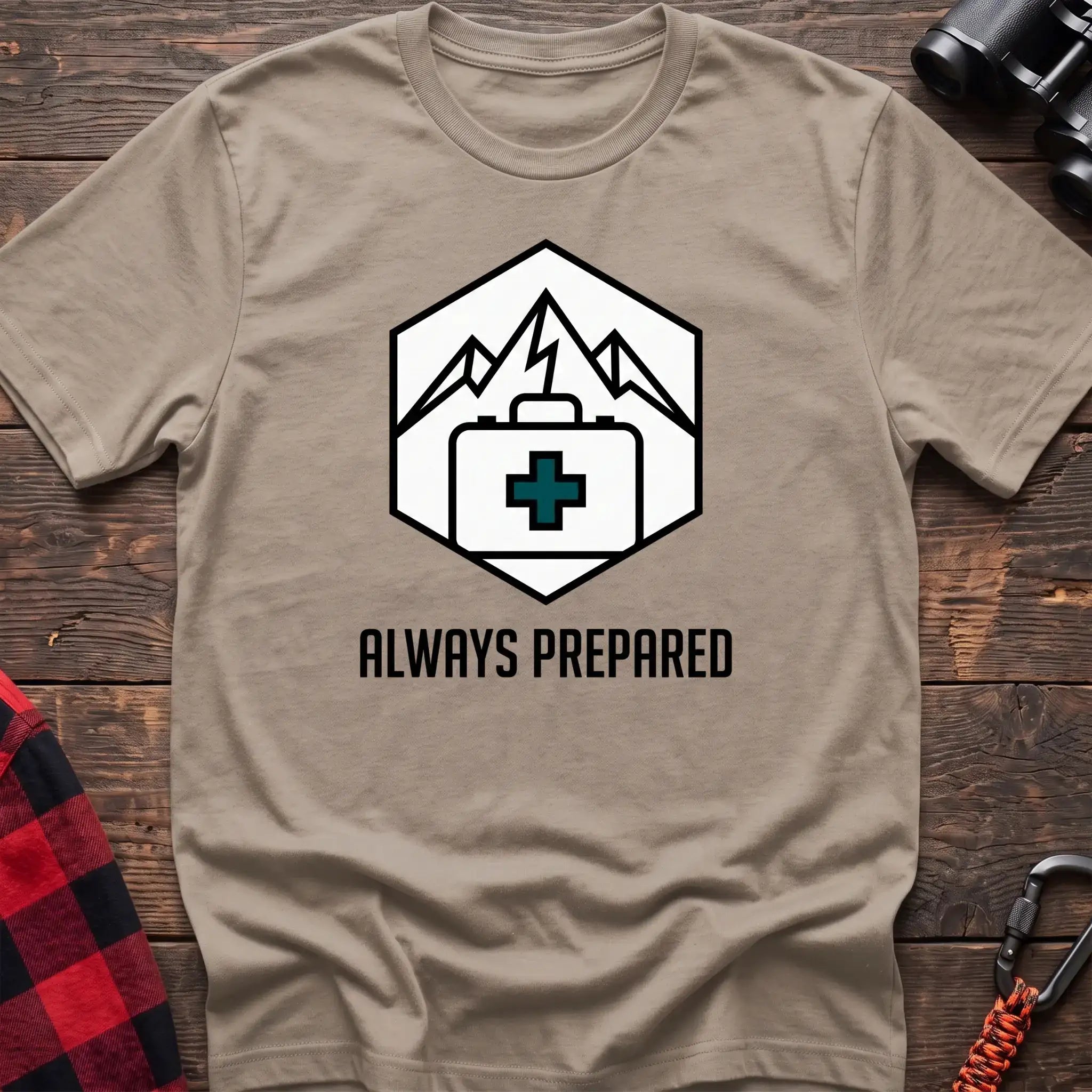 Sand t-shirt with hexagonal badge graphic of mountains and a first aid kit, reading Always Prepared