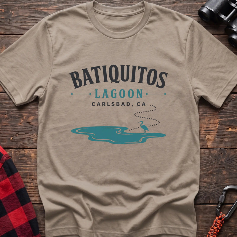 Sand cotton t-shirt with a heron and lagoon graphic and Batiquitos Lagoon Carlsbad CA text on rustic wood
