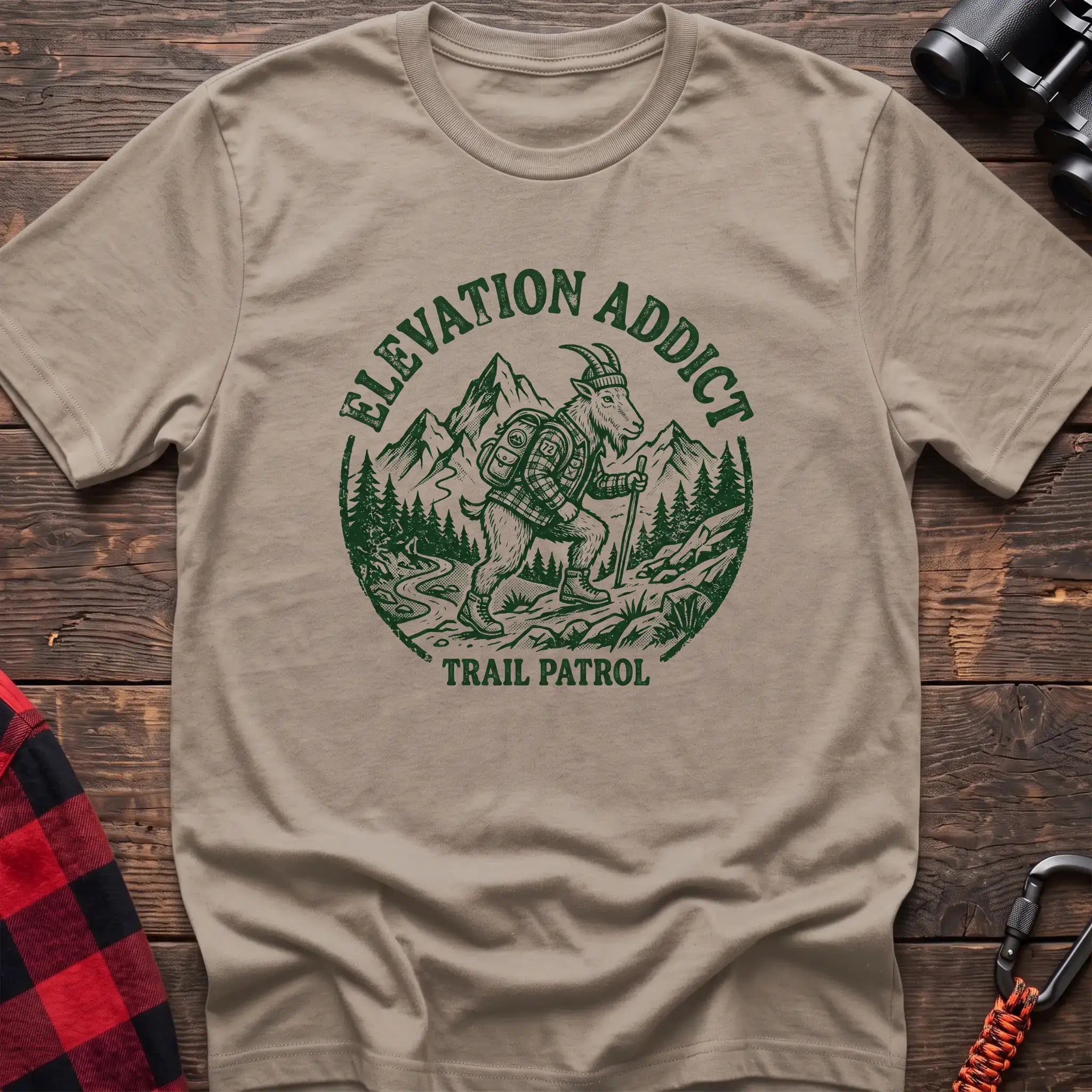 Sand t-shirt with circular graphic of a hiking mountain goat and the text Elevation Addict Trail Patrol