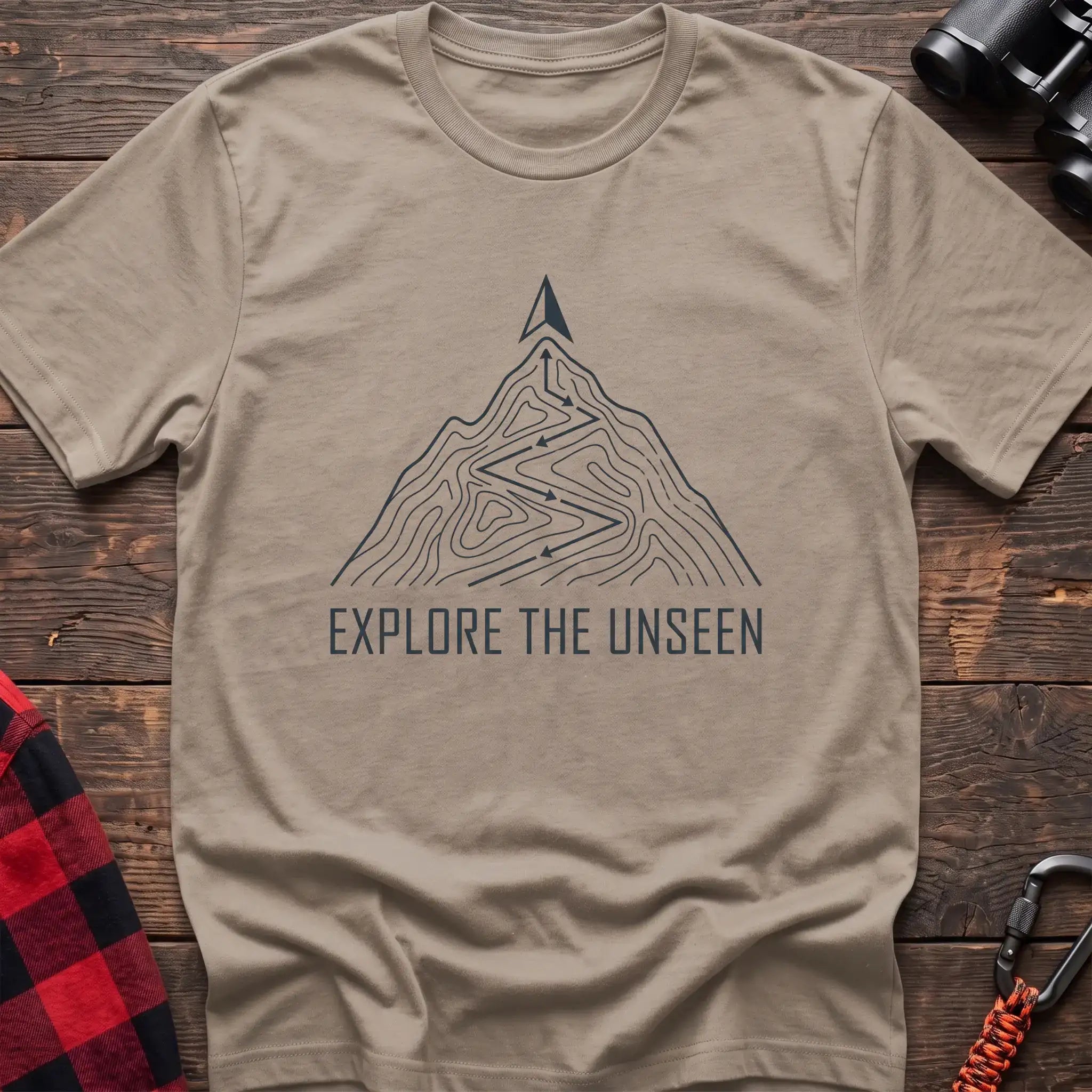 Sand t-shirt with topographic mountain trail graphic and the text Explore the Unseen