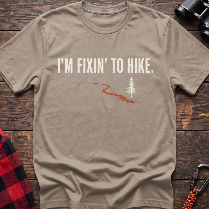 Sand cotton t-shirt with a trail and pine graphic and I’m Fixin’ to Hike text on rustic wood