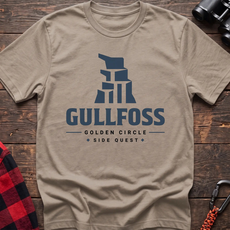 Sand cotton t-shirt with a stylized waterfall graphic and Gullfoss Golden Circle Side Quest text on rustic wood