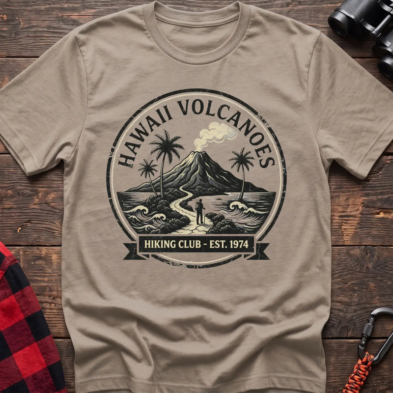 Sand t-shirt with circular Hawaii Volcanoes badge graphic showing a volcano, palm trees, and a hiker, reading Hiking Club Est 1974