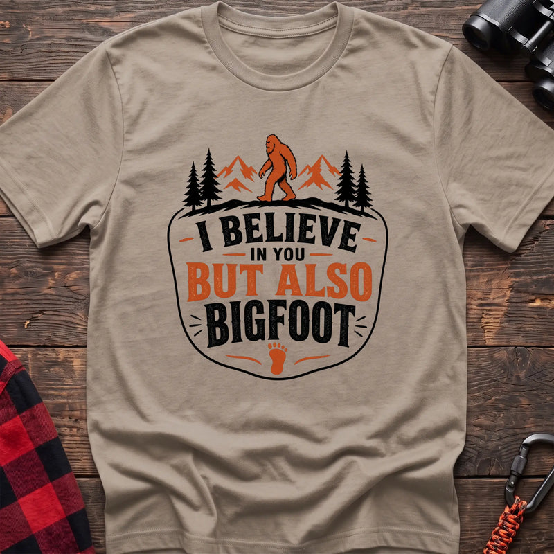 Sand hiking t-shirt with Bigfoot on a mountain ridge and I Believe in You But Also Bigfoot text