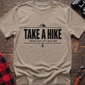 Sand cotton hiking t-shirt with "Take a Hike I Mean That in a Nice Way" quote, mountain icon, and pine tree graphic
