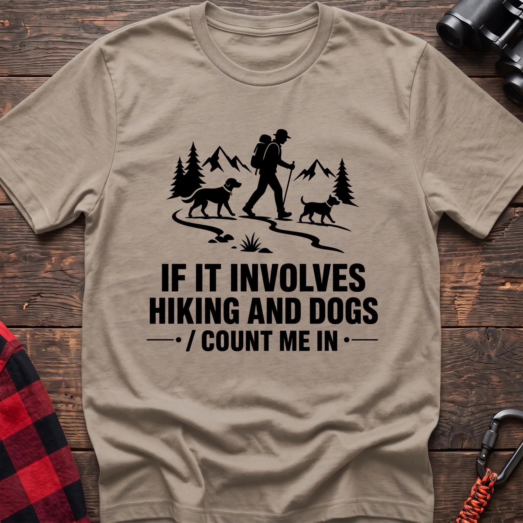 Sand cotton hiking t-shirt with hiker and two dogs silhouette on a mountain trail and "If it involves hiking and dogs count me in" quote