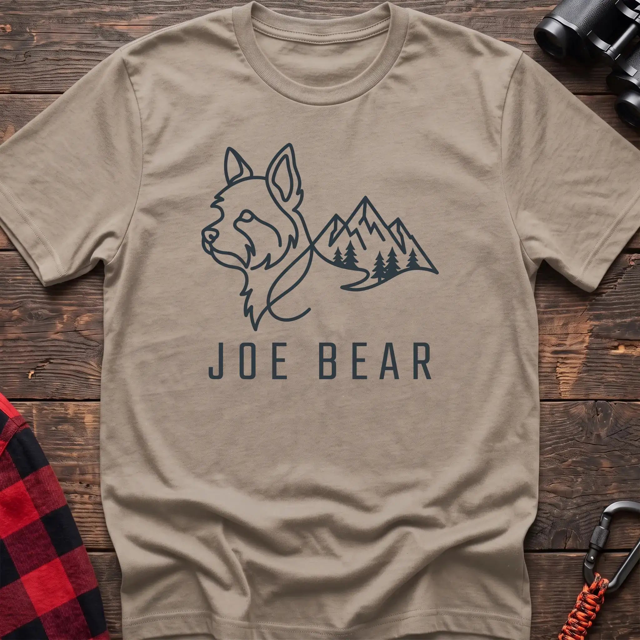 Sand t-shirt with dark line art of a yorkie dog head blending into mountains and pine trees, with the text Joe Bear