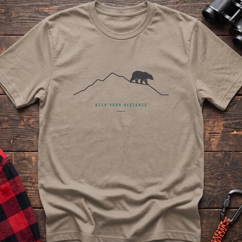 Sand hiking t-shirt with a line-art mountain, walking bear, and the text “Keep Your Distance”