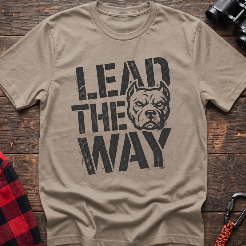 Sand t-shirt with a distressed graphic of a stern pit bull head integrated into the bold text “LEAD THE WAY,” laid flat on a wooden surface.