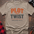 Sand cotton t-shirt with a mountain graphic and Plot Twist Another Hill text on rustic wood