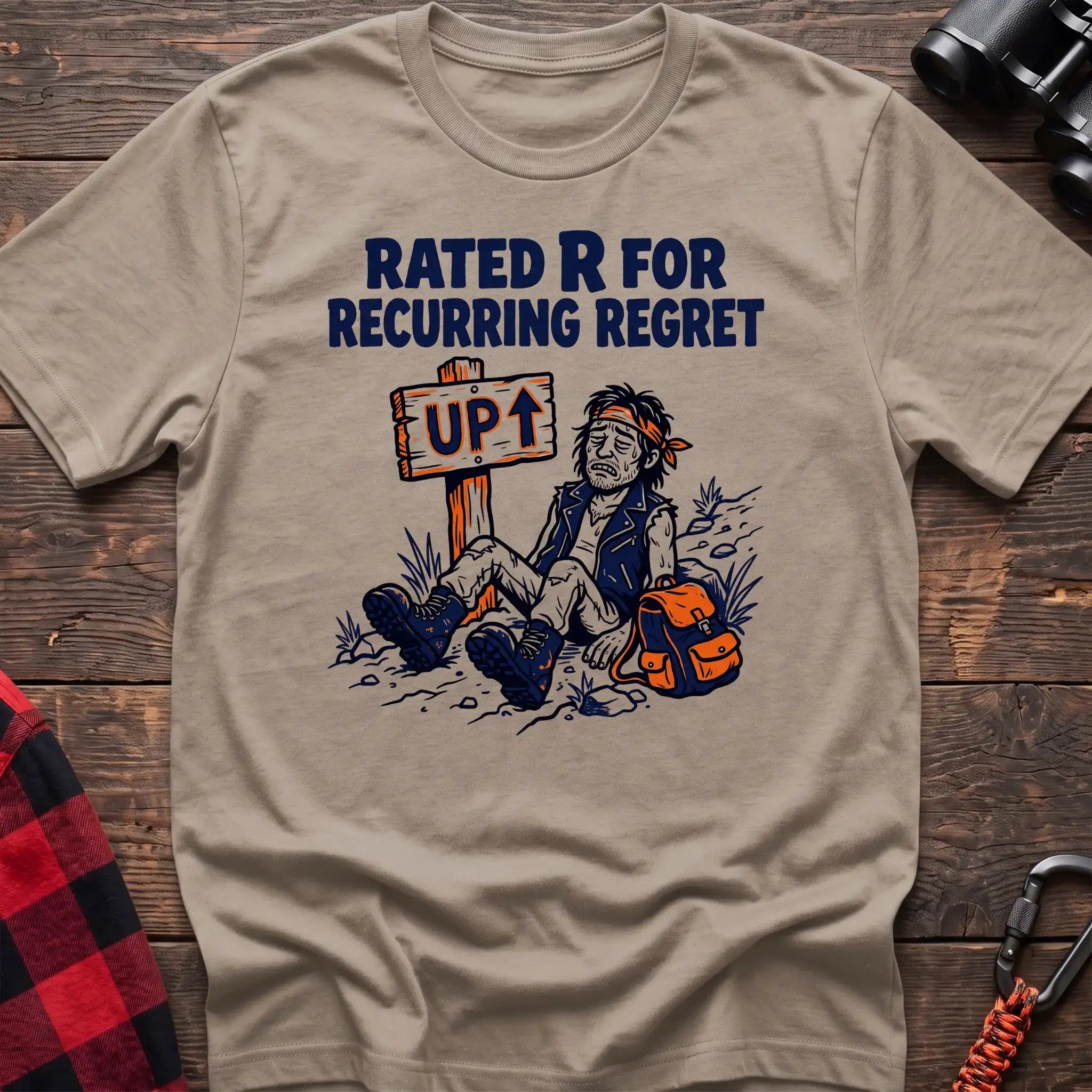 Sand t-shirt with illustration of an exhausted hiker sitting by an UP trail sign and the text Rated R for Recurring Regret