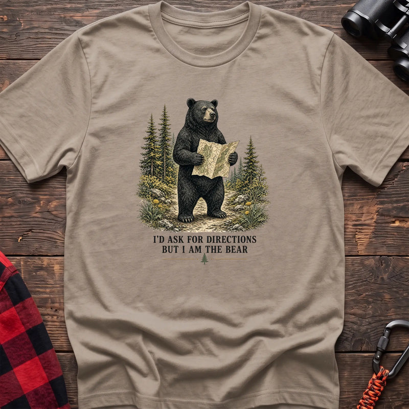 Sand cotton t-shirt with a bear holding a map graphic and I’d Ask for Directions But I Am the Bear text on rustic wood