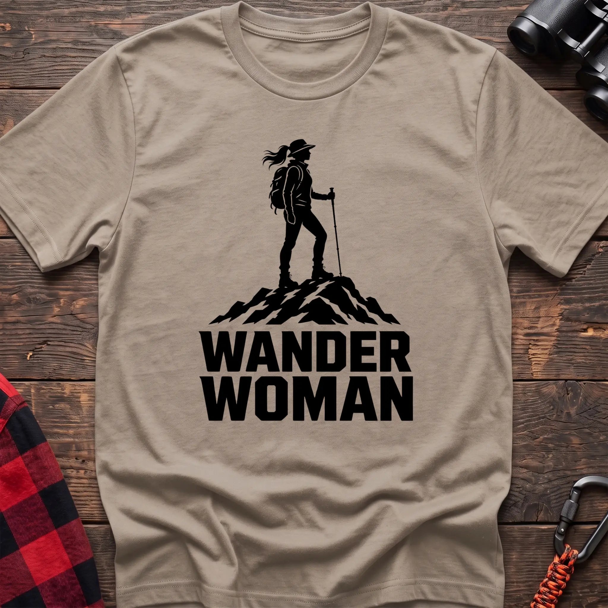 Sand cotton hiking t-shirt with black silhouette of a female hiker on a mountain peak and bold Wander Woman text