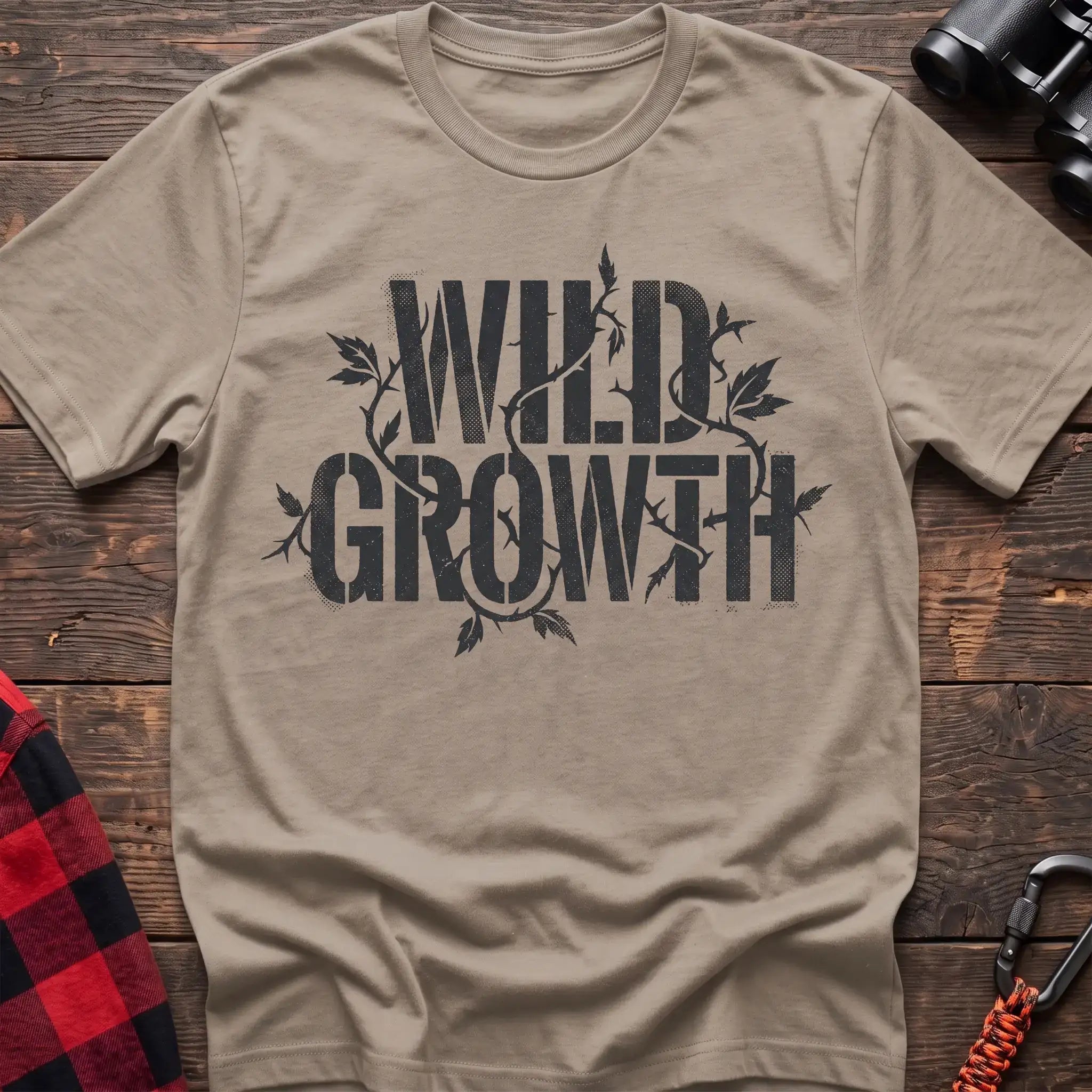 Sand t-shirt with dark text reading Wild Growth intertwined with thorny vines and leaves