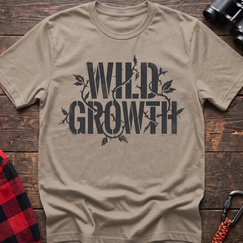 Sand t-shirt with dark text reading Wild Growth intertwined with thorny vines and leaves