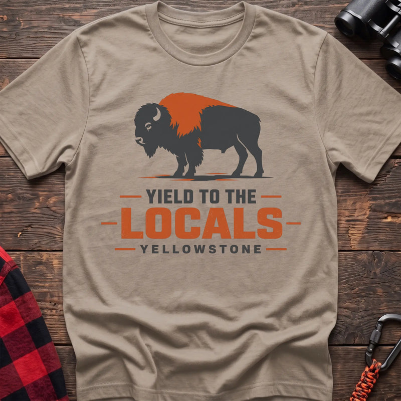 Sand cotton t-shirt with a bison graphic and Yield to the Locals Yellowstone text on rustic wood