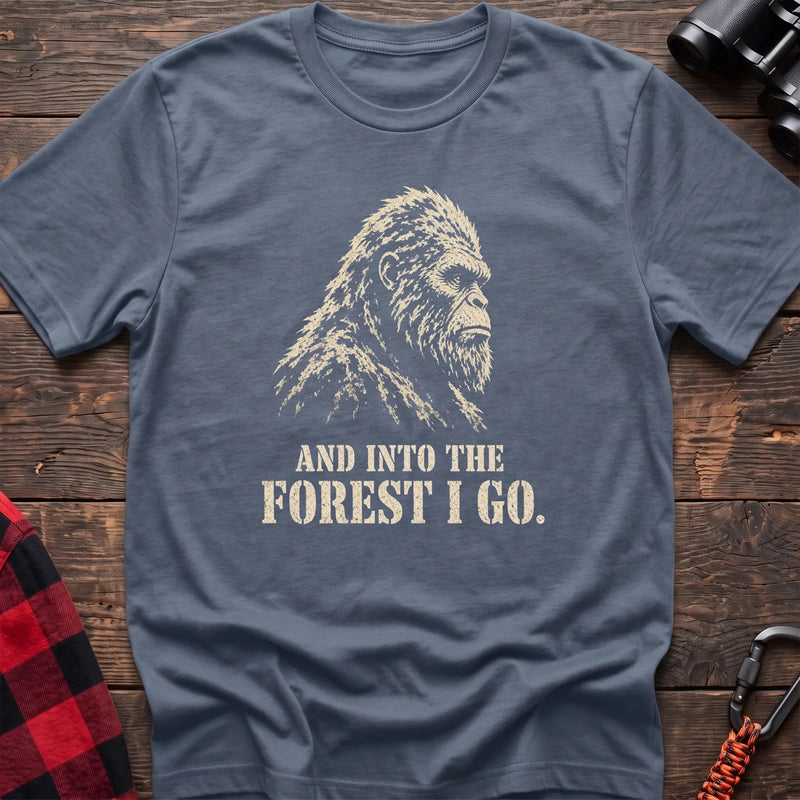 Stone blue cotton t-shirt with a Bigfoot graphic and And Into the Forest I Go text on rustic wood