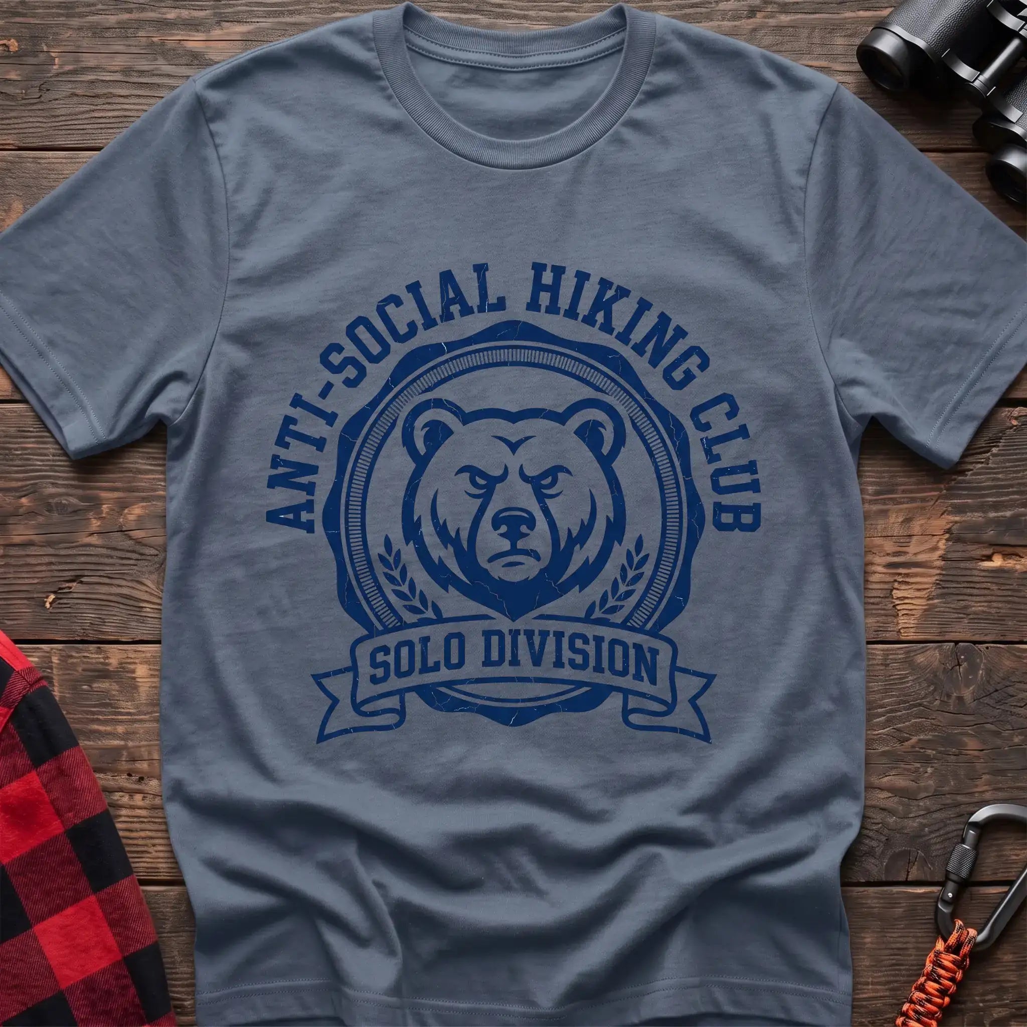 Stone blue t-shirt with circular badge of a serious bear face reading Anti-Social Hiking Club Solo Division