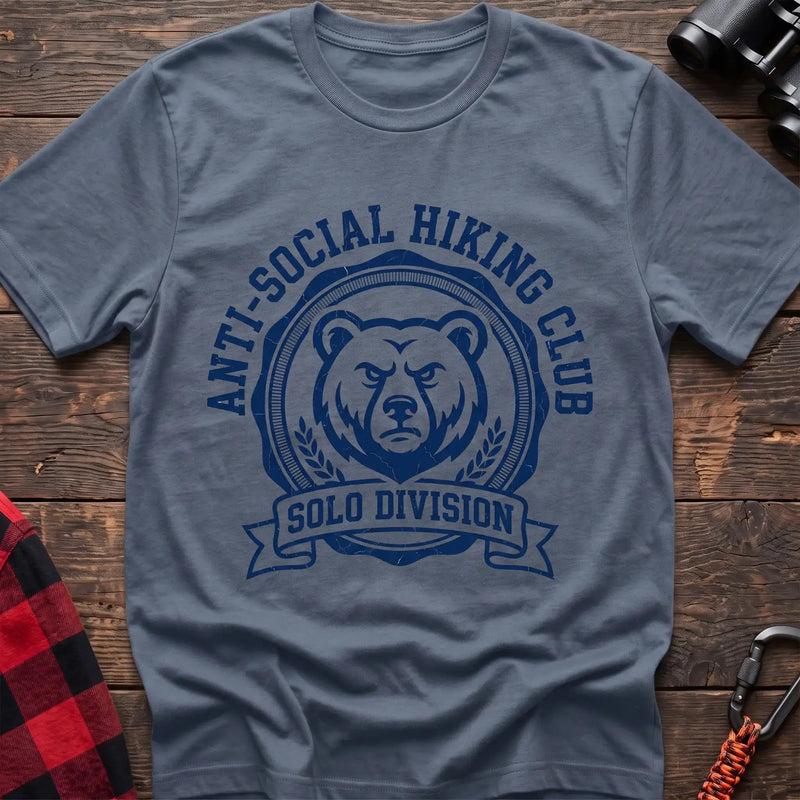 Stone blue t-shirt with circular badge of a serious bear face reading Anti-Social Hiking Club Solo Division