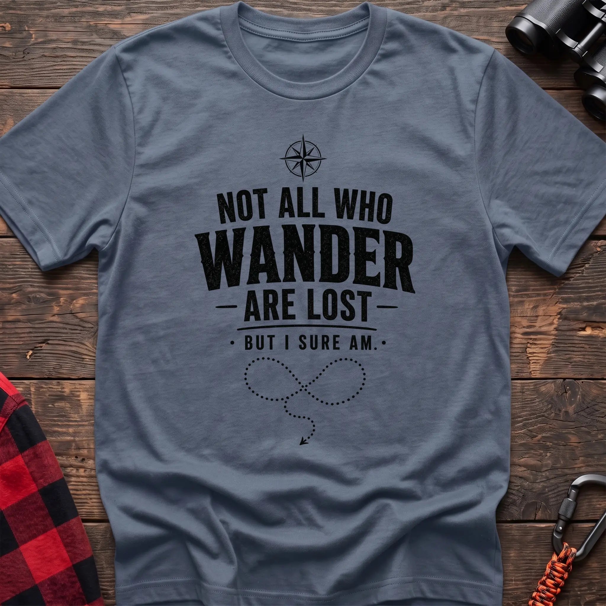 Stone blue cotton hiking t-shirt with compass, "Not all who wander are lost but I sure am" quote, and dotted wandering path graphic