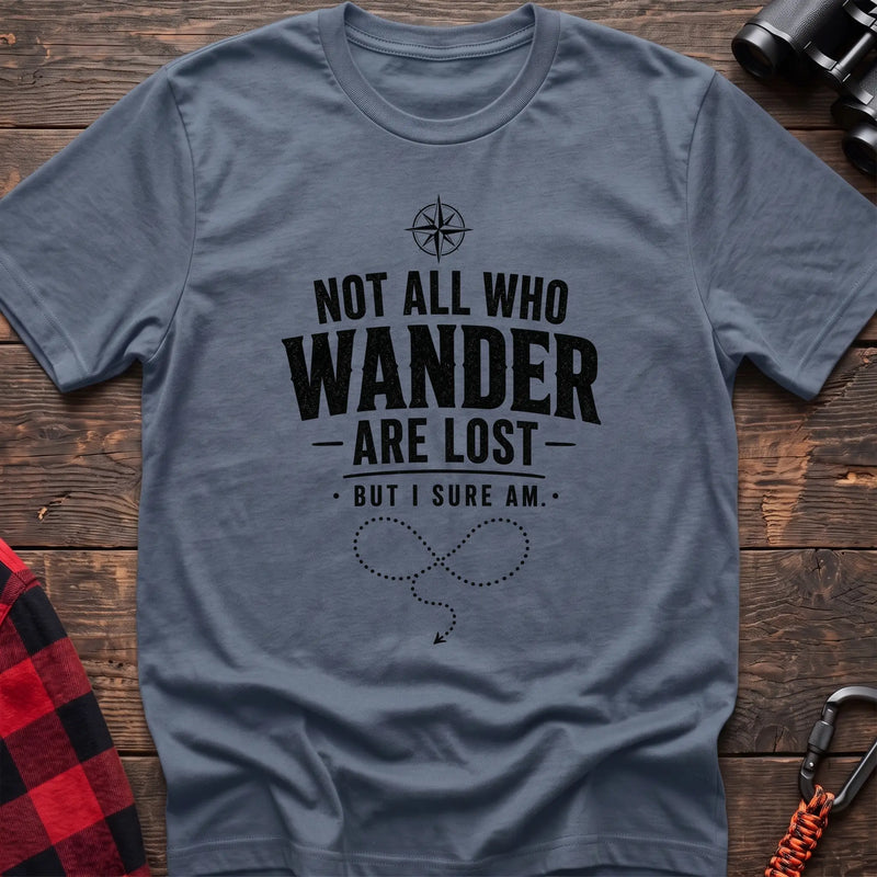 Stone blue cotton hiking t-shirt with compass, "Not all who wander are lost but I sure am" quote, and dotted wandering path graphic