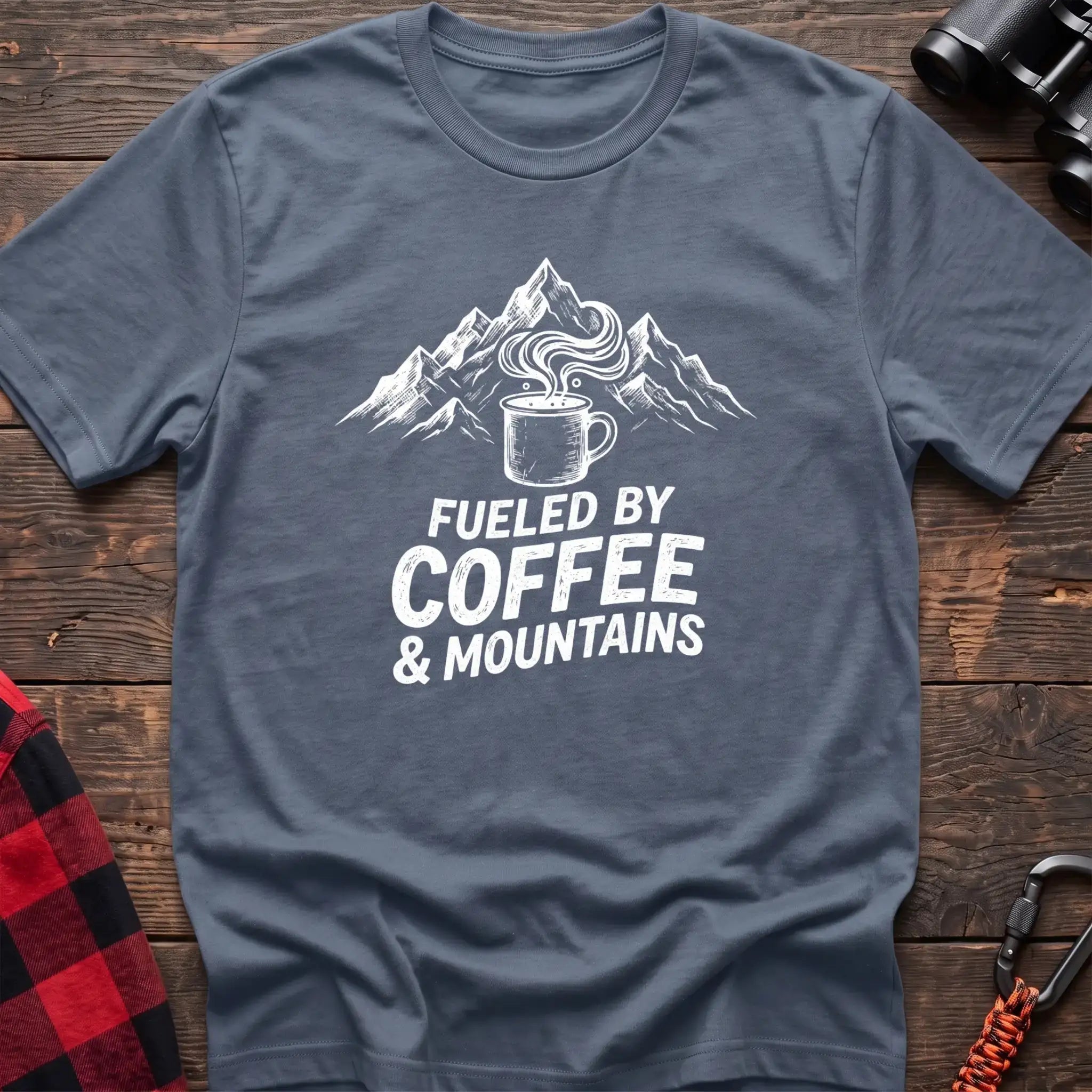 Stone blue t-shirt with white graphic of a steaming coffee mug in front of mountains and the text Fueled by Coffee & Mountains
