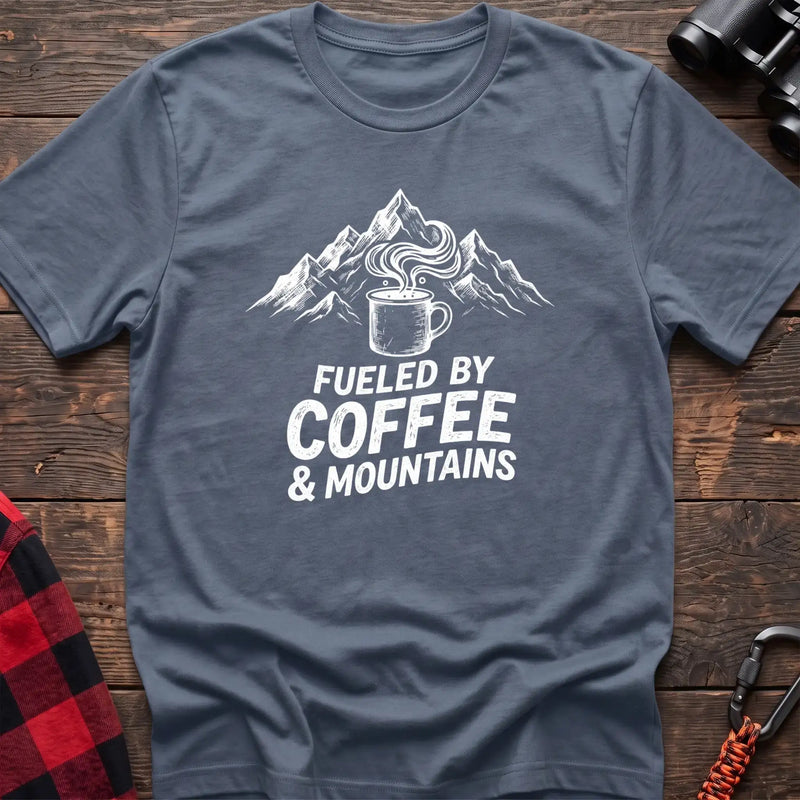 Stone blue t-shirt with white graphic of a steaming coffee mug in front of mountains and the text Fueled by Coffee & Mountains