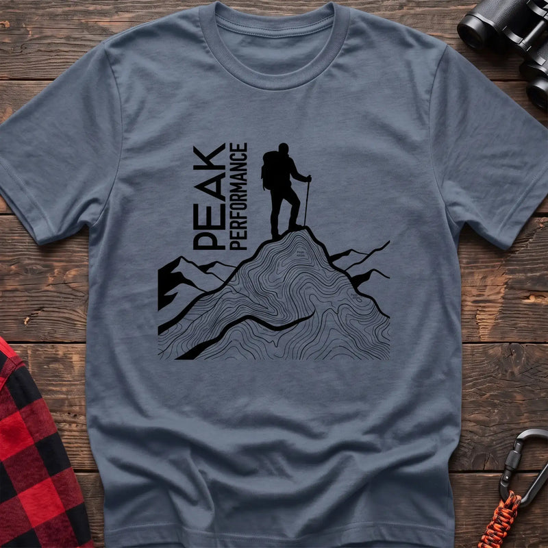 Stone blue t-shirt with hiker silhouette on a topographic mountain peak and the text Peak Performance
