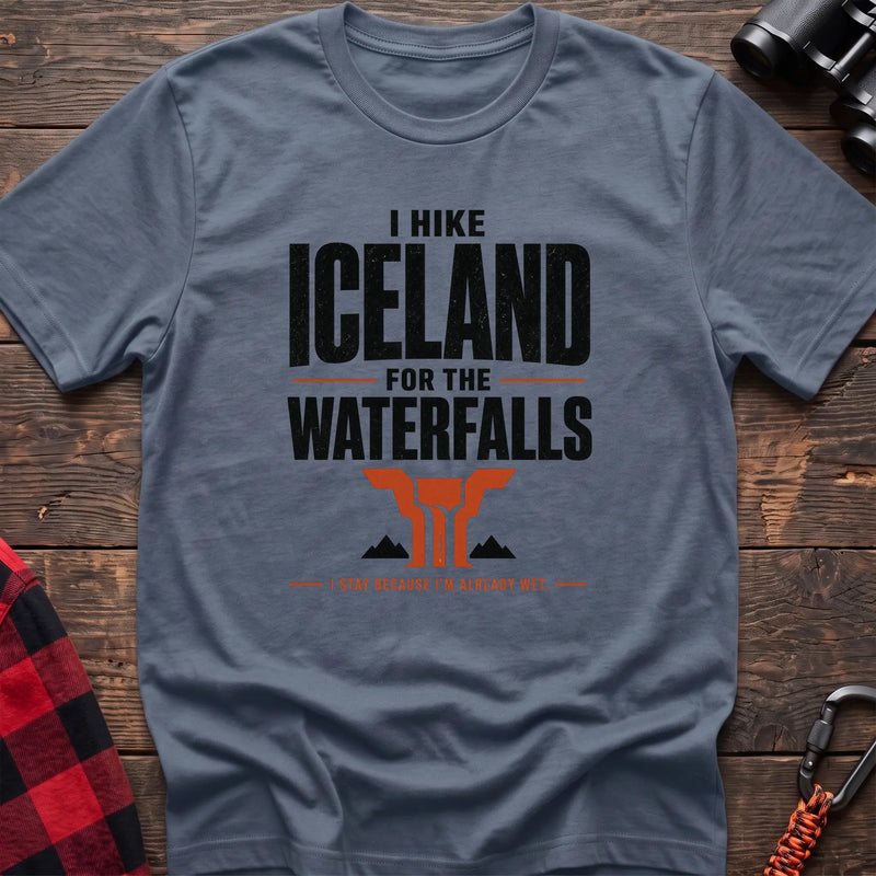 Stone blue cotton t-shirt with a waterfall graphic and I Hike Iceland for the Waterfalls text on rustic wood