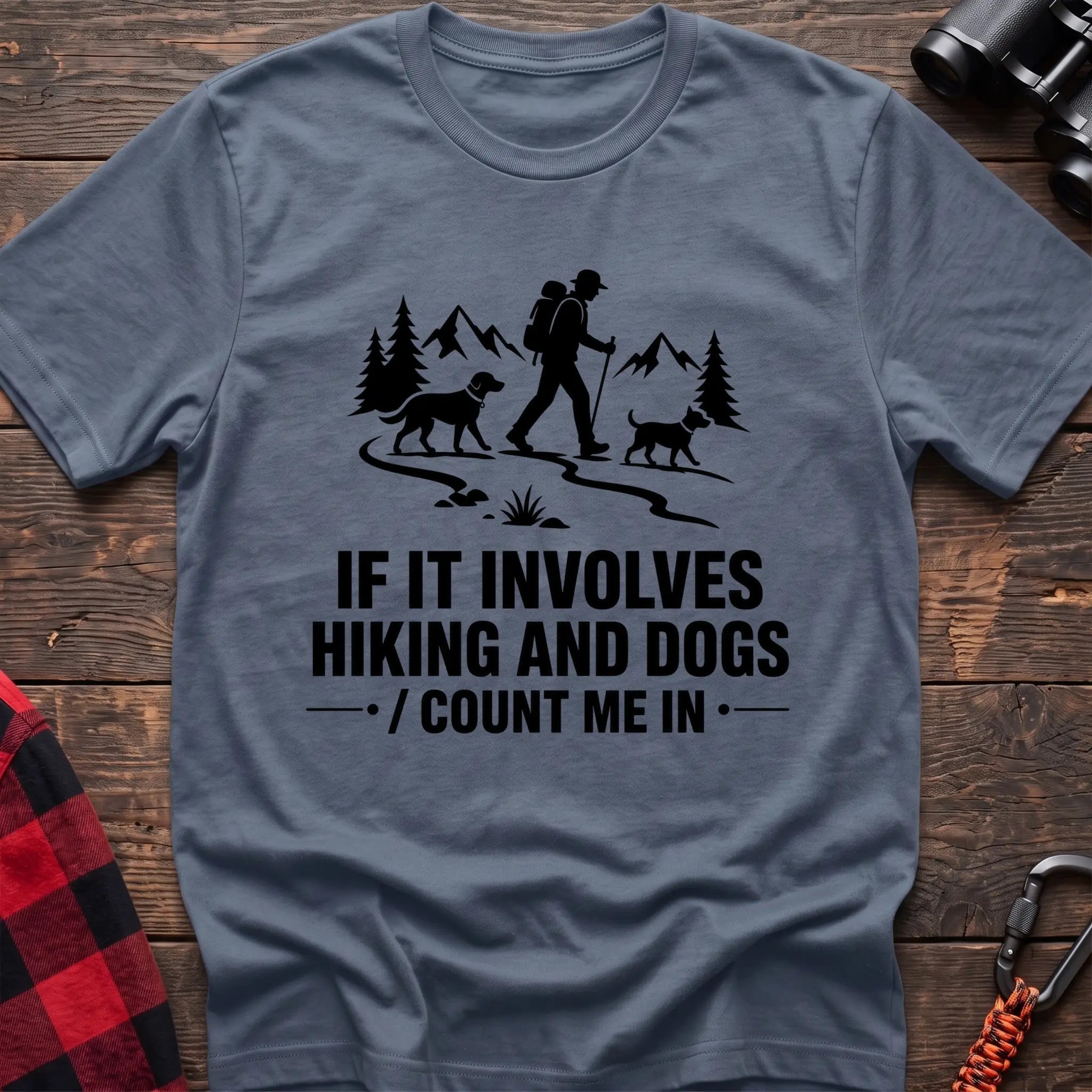 Stone blue cotton hiking t-shirt with hiker and two dogs silhouette on a mountain trail and "If it involves hiking and dogs count me in" quote