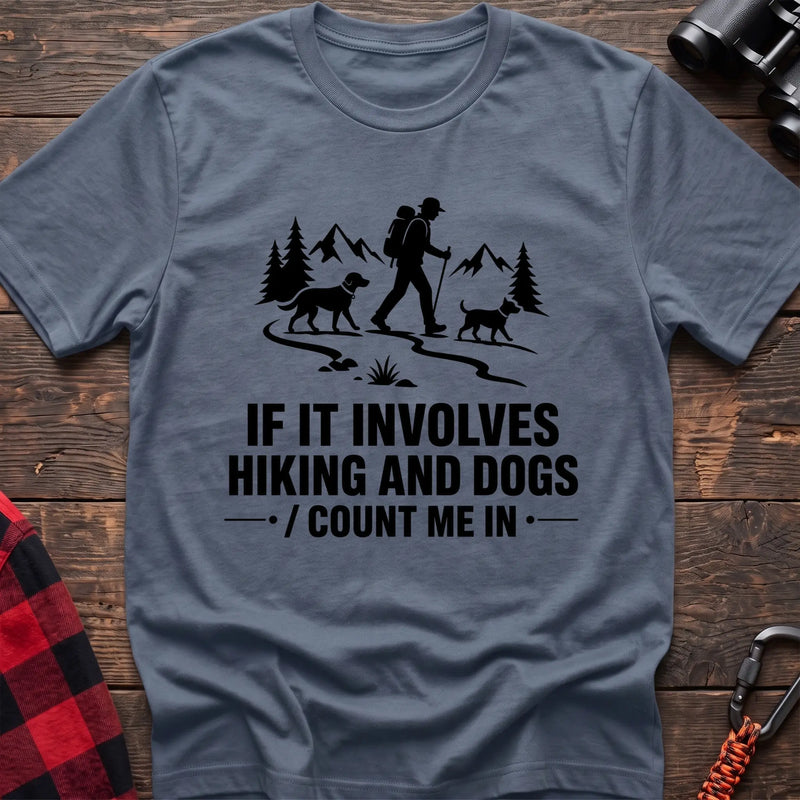 Stone blue cotton hiking t-shirt with hiker and two dogs silhouette on a mountain trail and "If it involves hiking and dogs count me in" quote