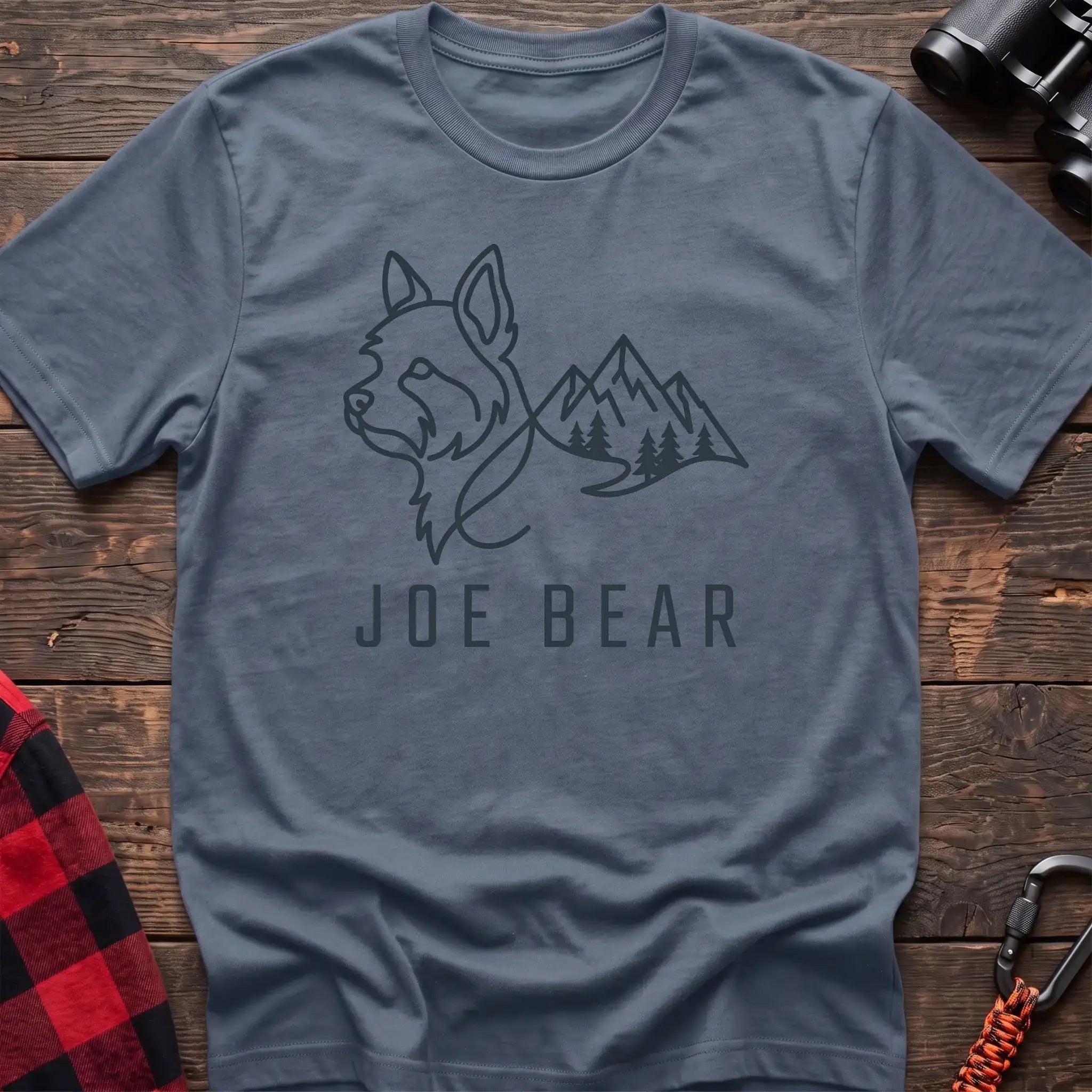 Stone blue t-shirt with dark line art of a yorkie dog head blending into mountains and pine trees, with the text Joe Bear