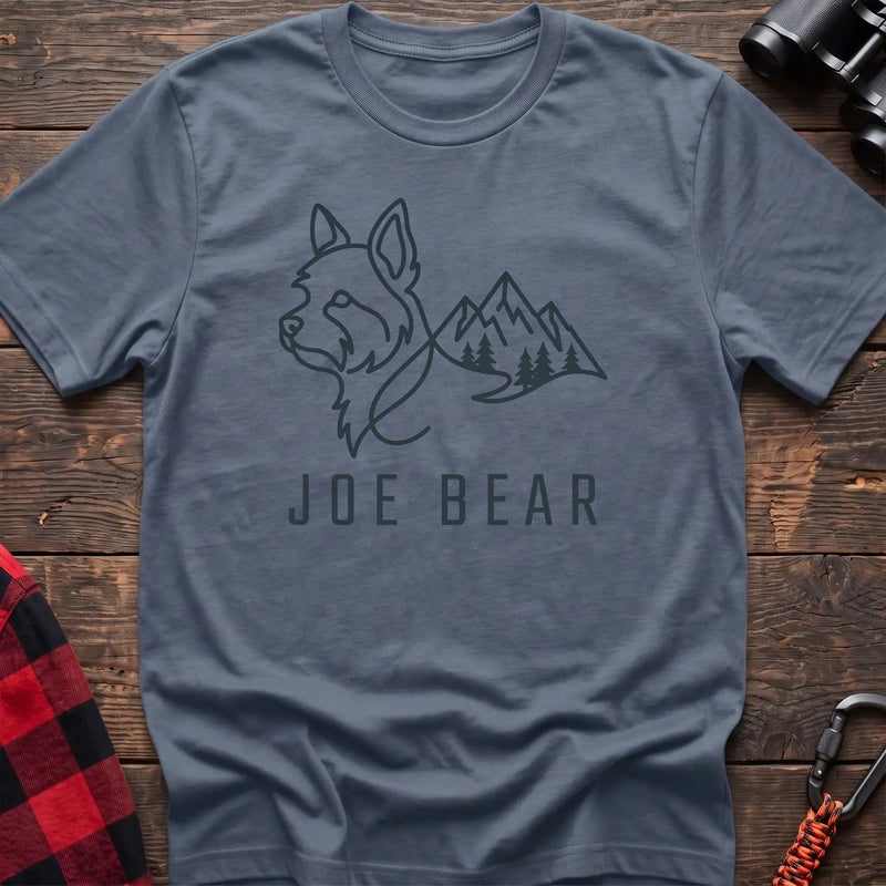 Stone blue t-shirt with dark line art of a yorkie dog head blending into mountains and pine trees, with the text Joe Bear