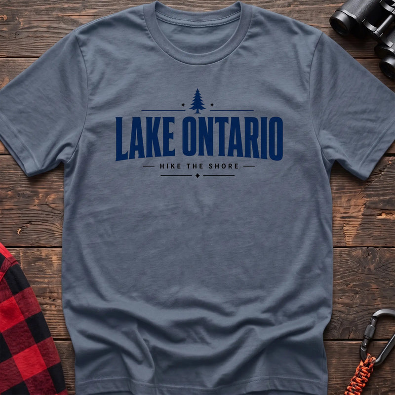 Stone blue cotton hiking t-shirt with pine tree icon and "Lake Ontario hike the shore" text