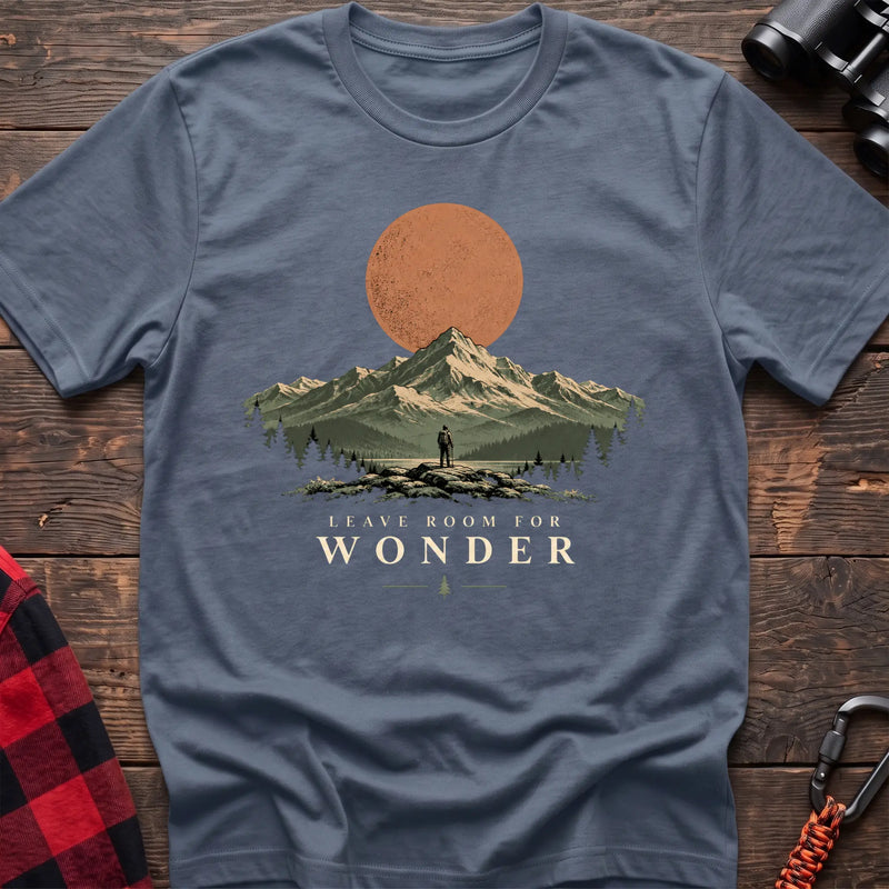 Stone blue cotton t-shirt with a hiker and mountain sunset graphic and Leave Room for Wonder text on rustic wood