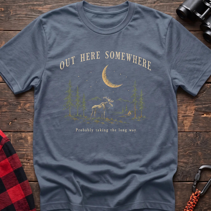 Stone blue cotton t-shirt with a moonlit moose and pines graphic and Out Here Somewhere text on rustic wood